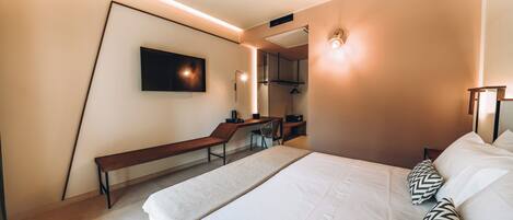 Ein modernes Hotelzimmer mit einem großen Bett, einem Schreibtisch und einem Stuhl.