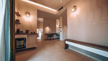 Een moderne keuken met inbouwapparatuur, een eethoek met een tafel en stoelen, en een bank langs de muur.