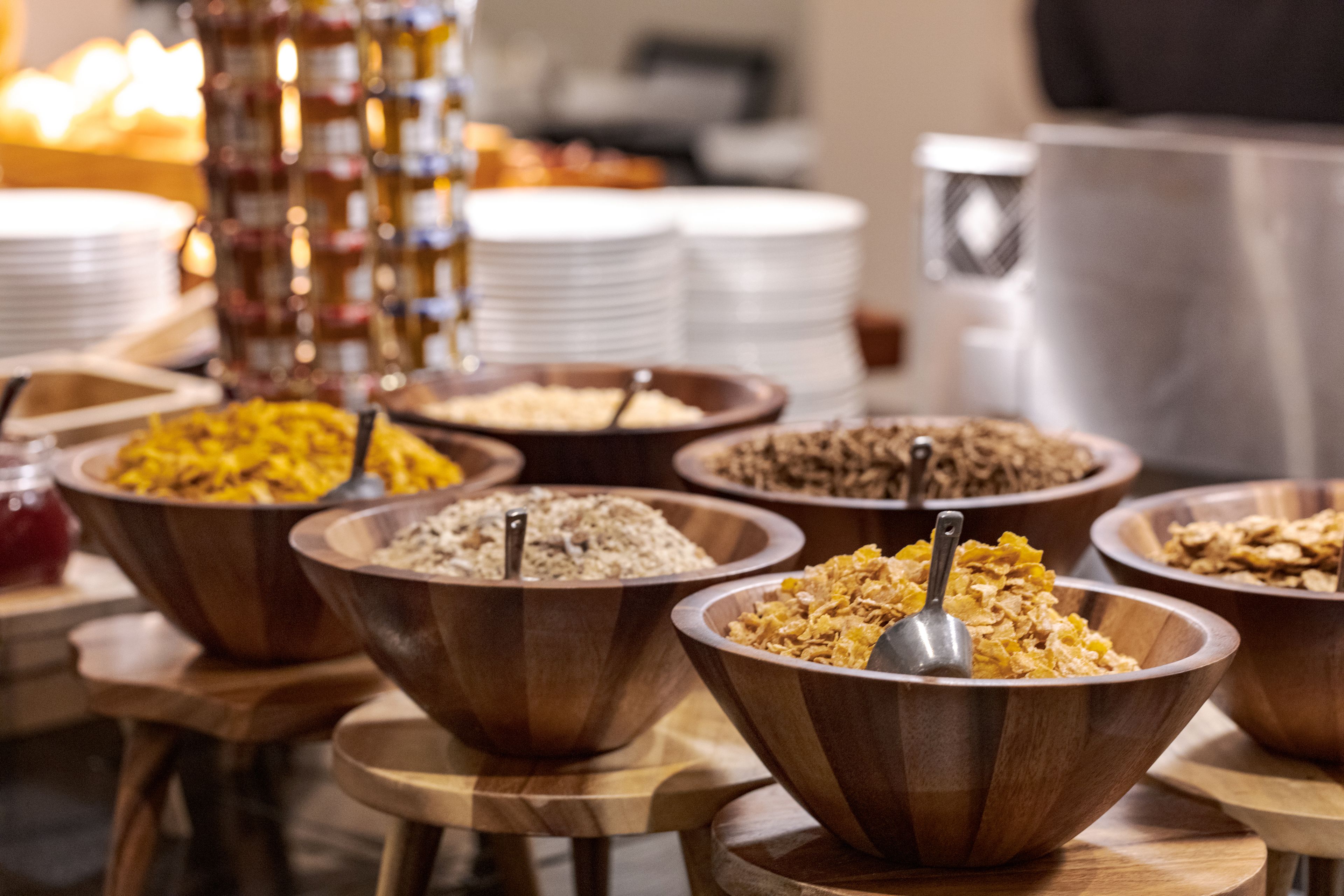 A buffet with various food items in wooden bowls.