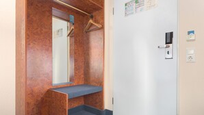 A bathroom with a mirror, a towel rack, and a door with a lock and a card reader. - Trip Inn Hotel Minerva (Frankfurt)