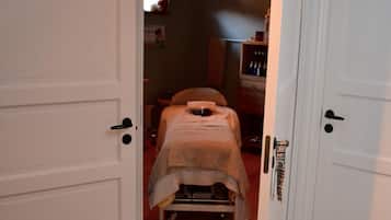 Un pasillo estrecho que conduce a un dormitorio con cama y cómoda.