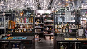 Eine Bar mit Regalen voller verschiedener Flaschen und Gläser.
