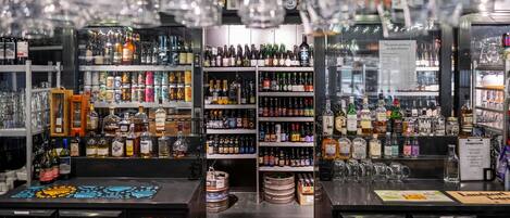 A bar with shelves stocked with various bottles and glasses.