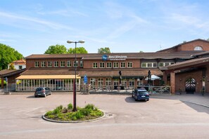 Un hôtel doté d’un grand parking, d’une entrée abritée et d’une façade en briques.