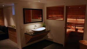 A modern bathroom with a large sink, mirror, and wooden accents. - Grand Hotel Alingsås (Alingsas)