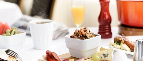 A breakfast setting with various dishes, including toast, fruit, cheese, and a bowl of cereal.