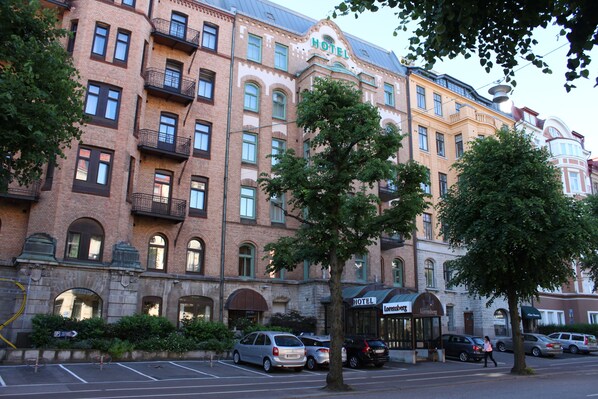 A multi-story hotel with a classic architectural style, featuring arched windows and balconies.