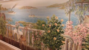 A mural depicting a coastal scene with boats, a pier, and potted plants. - Hotel Lorensberg (Gothenburg)