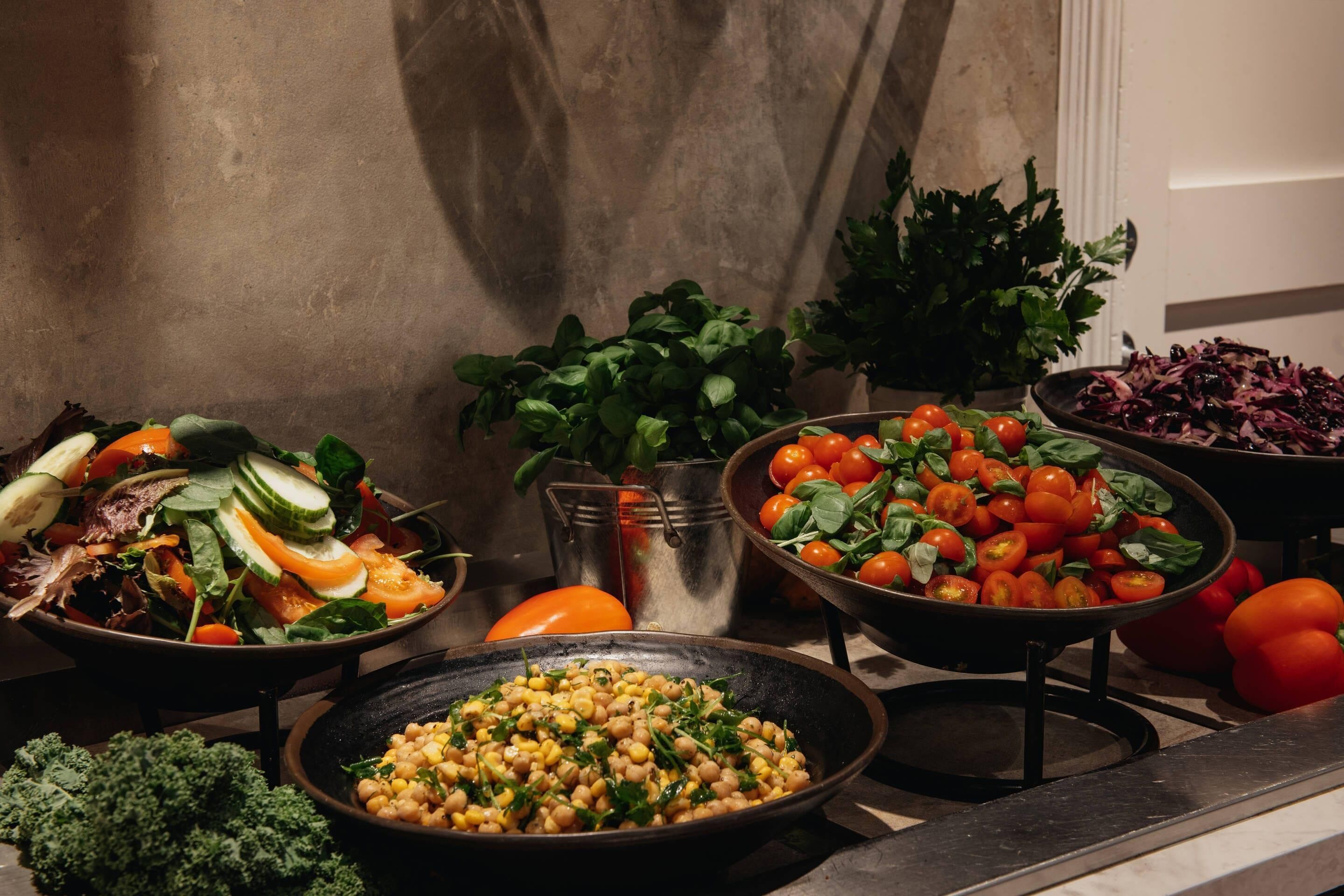 Diverse insalate fresche e verdure su un tavolo.