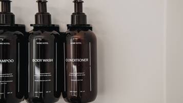 Three bottles of HOME HOTEL body wash, shampoo, and conditioner.