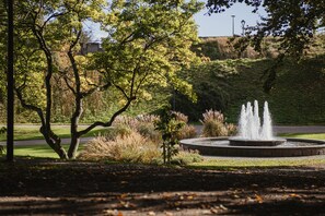 A fountain surrounded by trees and grass in a park setting. - Home Hotel Norre Park (Halmstad)