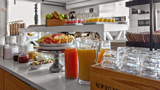 Un buffet de petit-déjeuner proposant une variété de fruits, de jus et de viennoiseries.