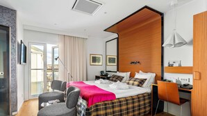 Une chambre d’hôtel moderne dotée d’un grand lit, d’un bureau, d’une chaise et d’un balcon avec vue.