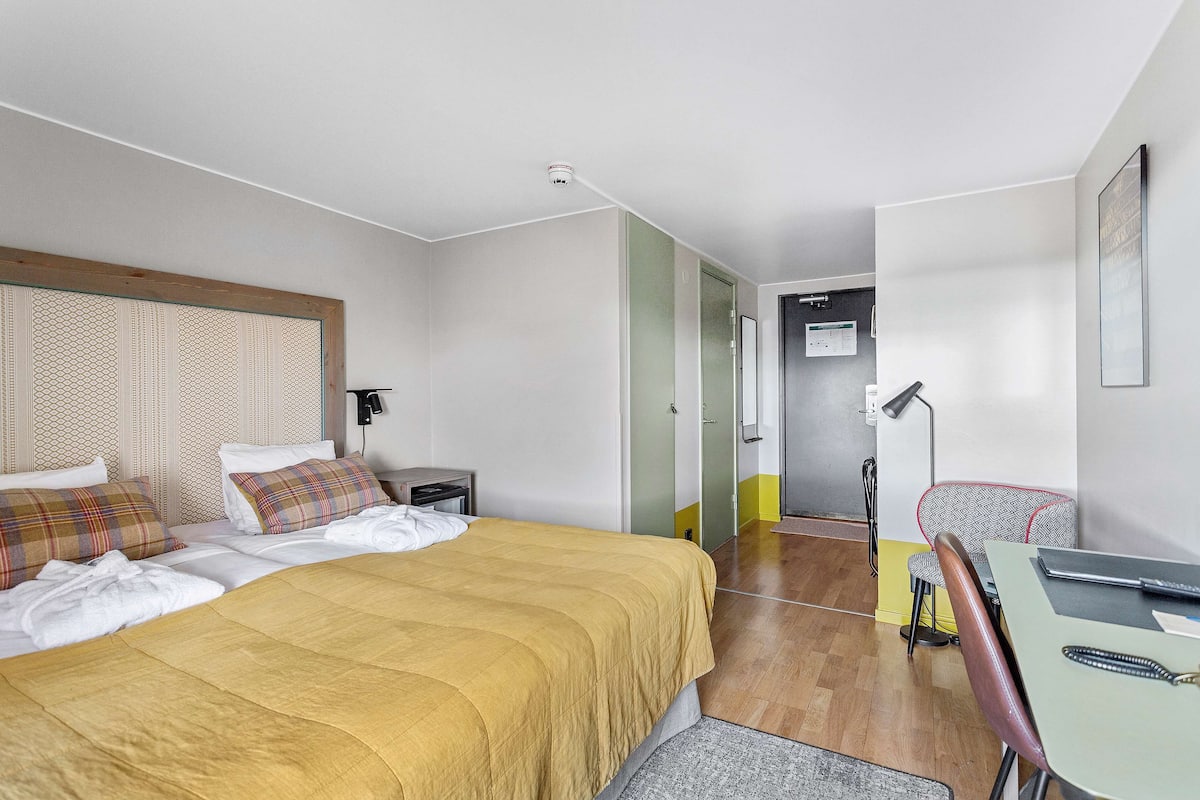Une chambre d’hôtel moderne avec un grand lit, un bureau et une chaise.