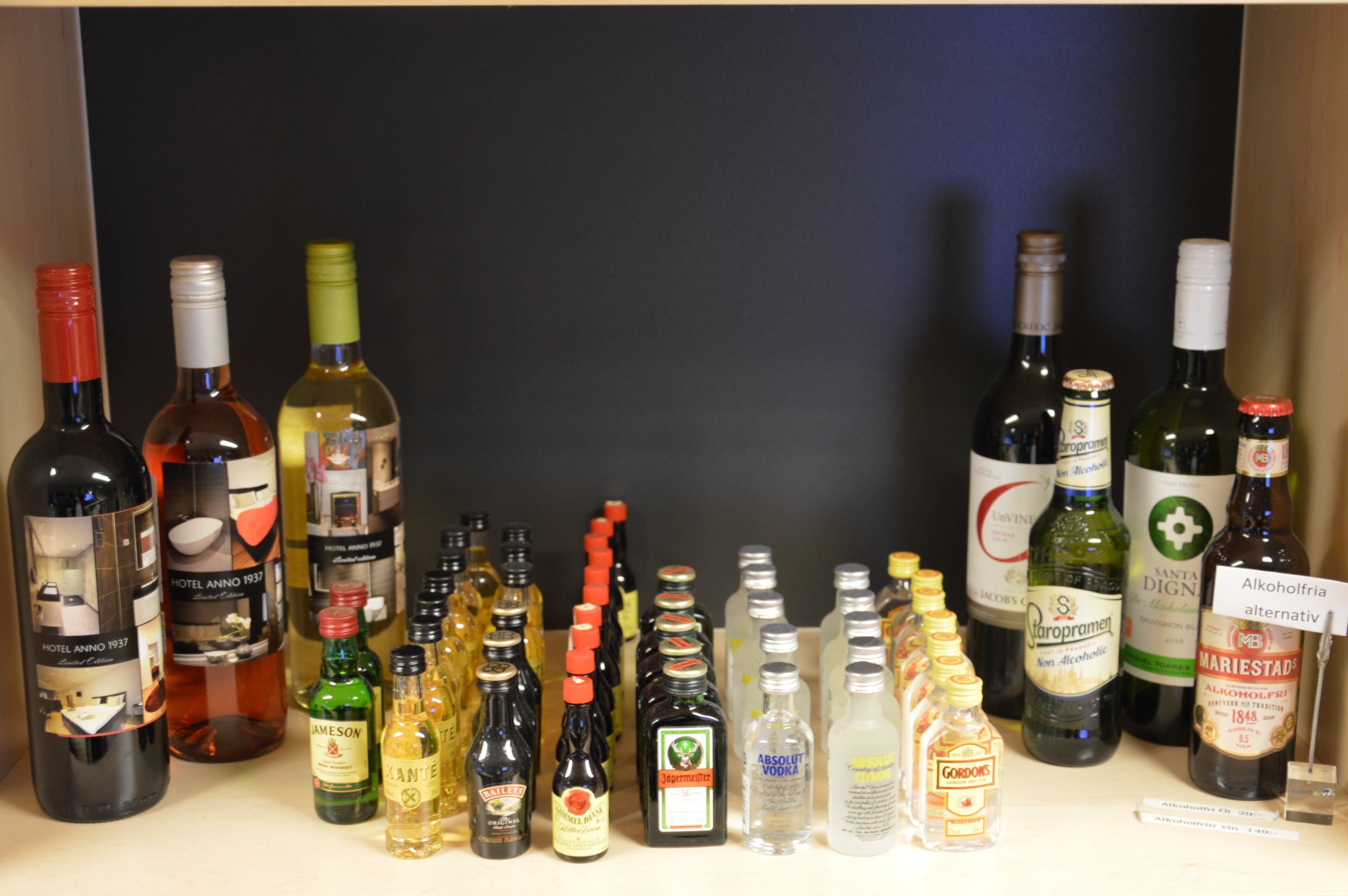 Diversas garrafas de bebidas alcoólicas expostas numa prateleira.