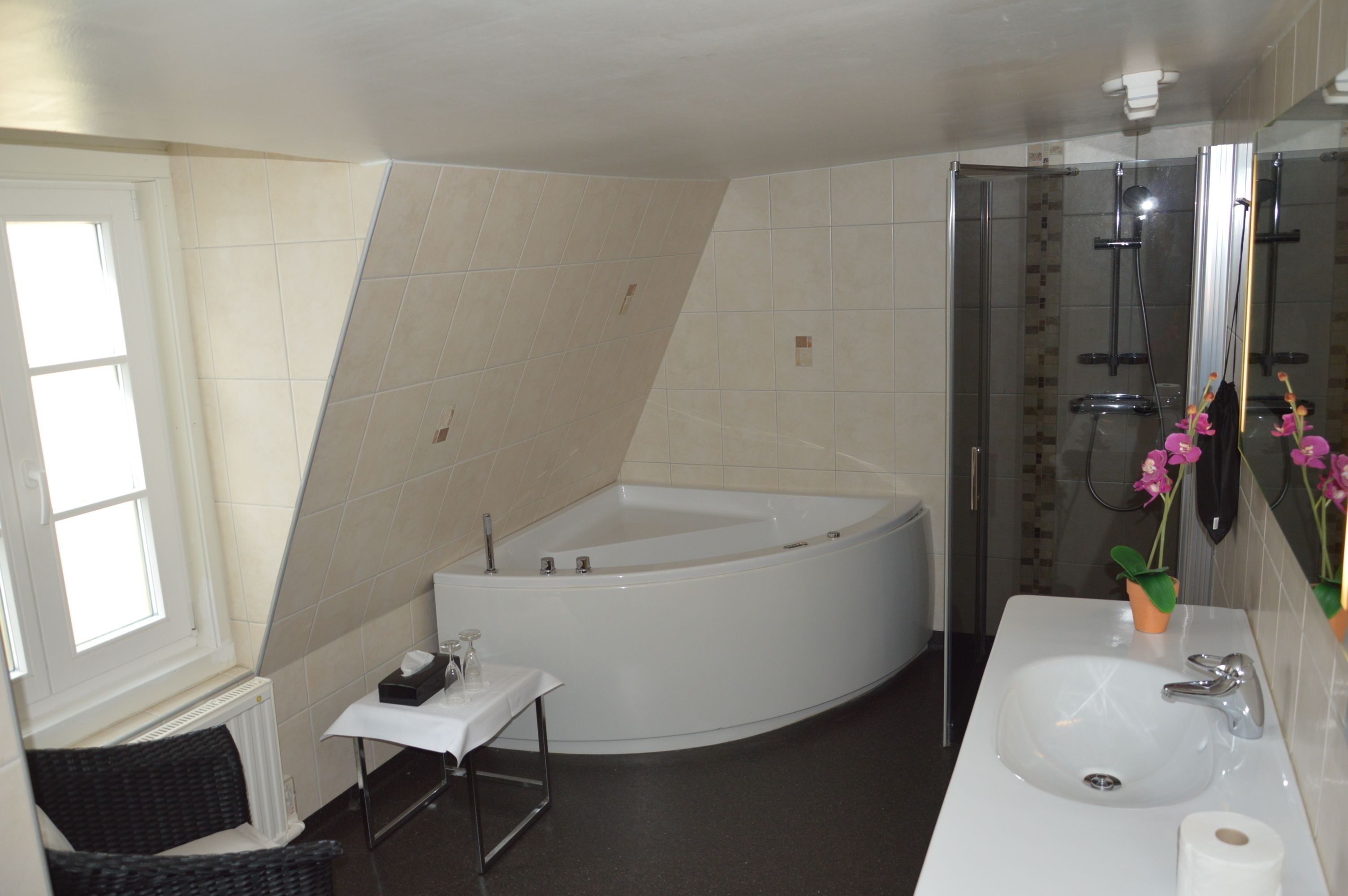 A modern bathroom with a freestanding bathtub, a sink, and a glass shower enclosure.