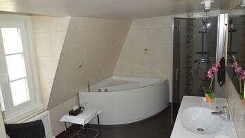 A modern bathroom with a freestanding bathtub, a sink, and a glass shower enclosure.