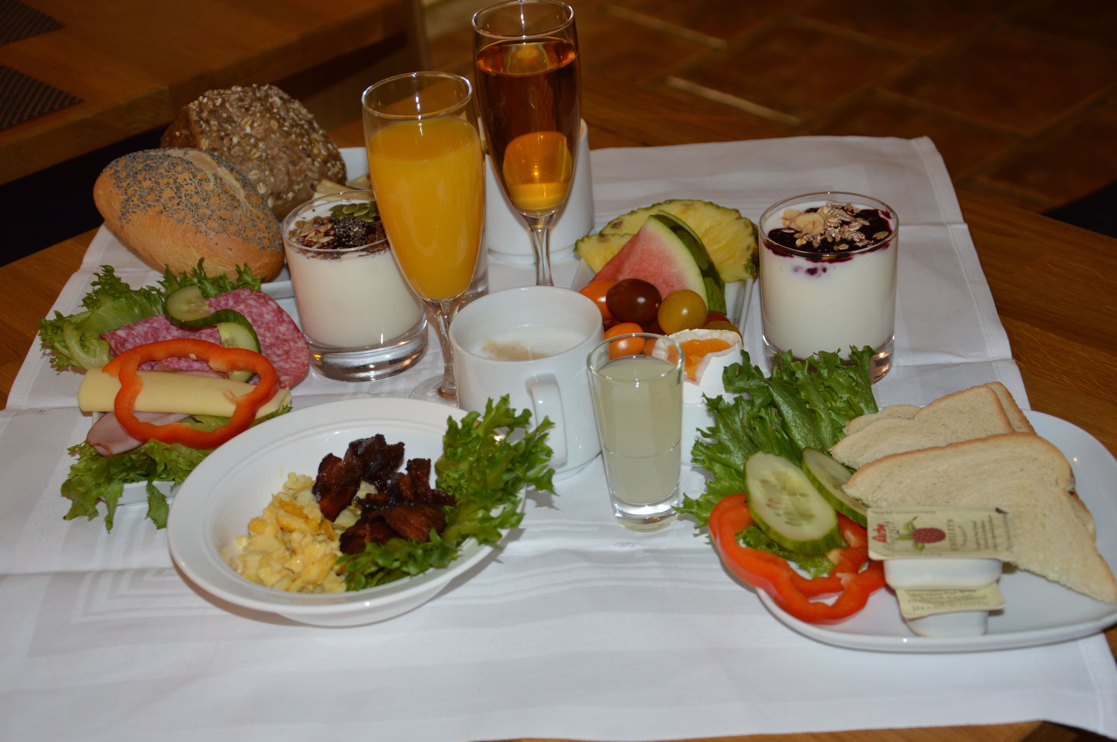 Una mesa con diversas opciones de comida, como sándwiches, frutas y bebidas.