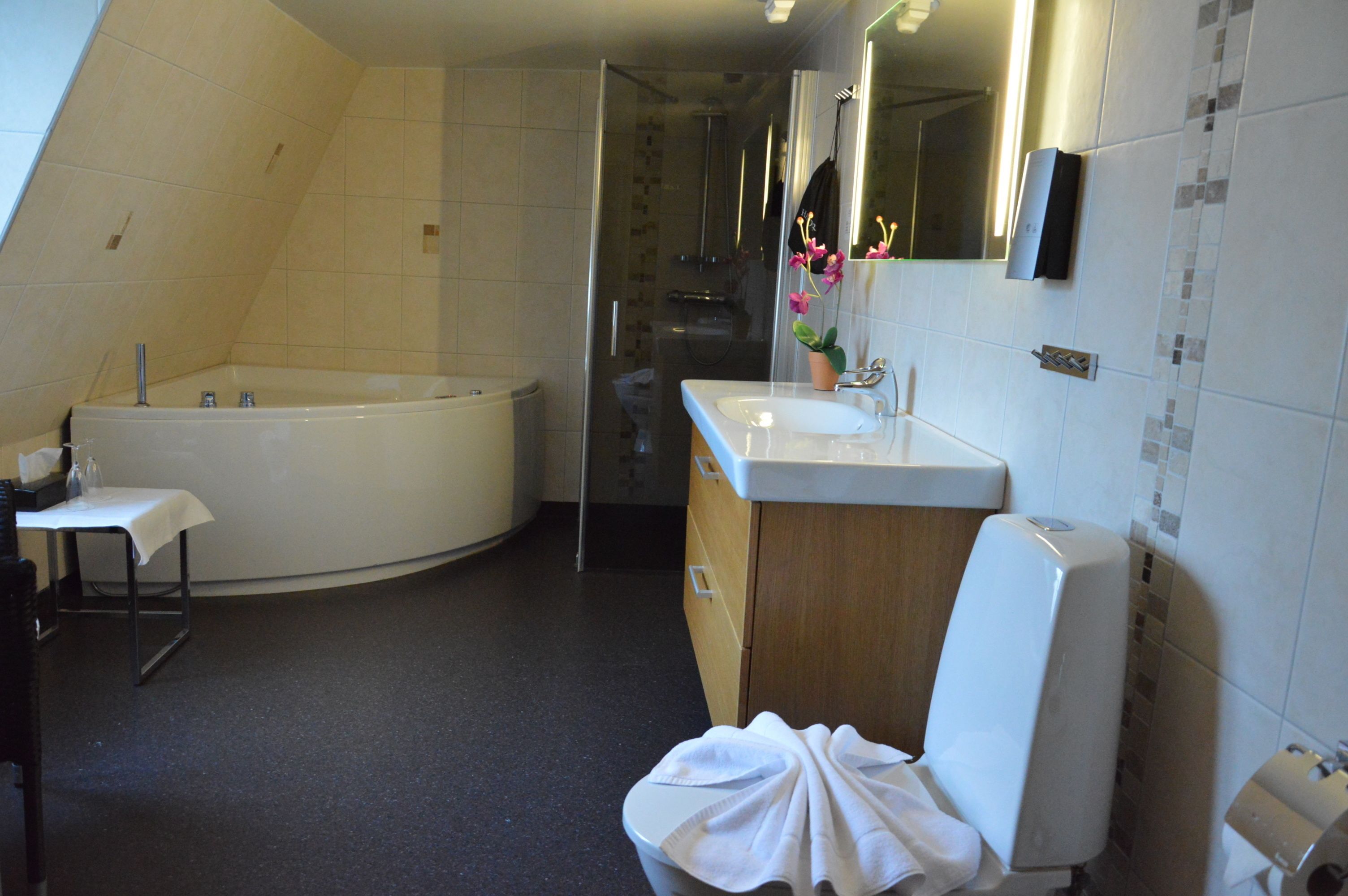 A bathroom with a bathtub, a sink, and a mirror.