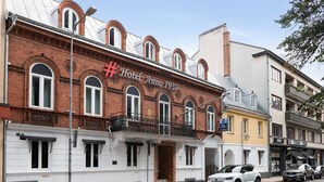 Un edificio histórico con un cartel que dice "Hotel Anno 1937" y un balcón con barandillas de hierro forjado.