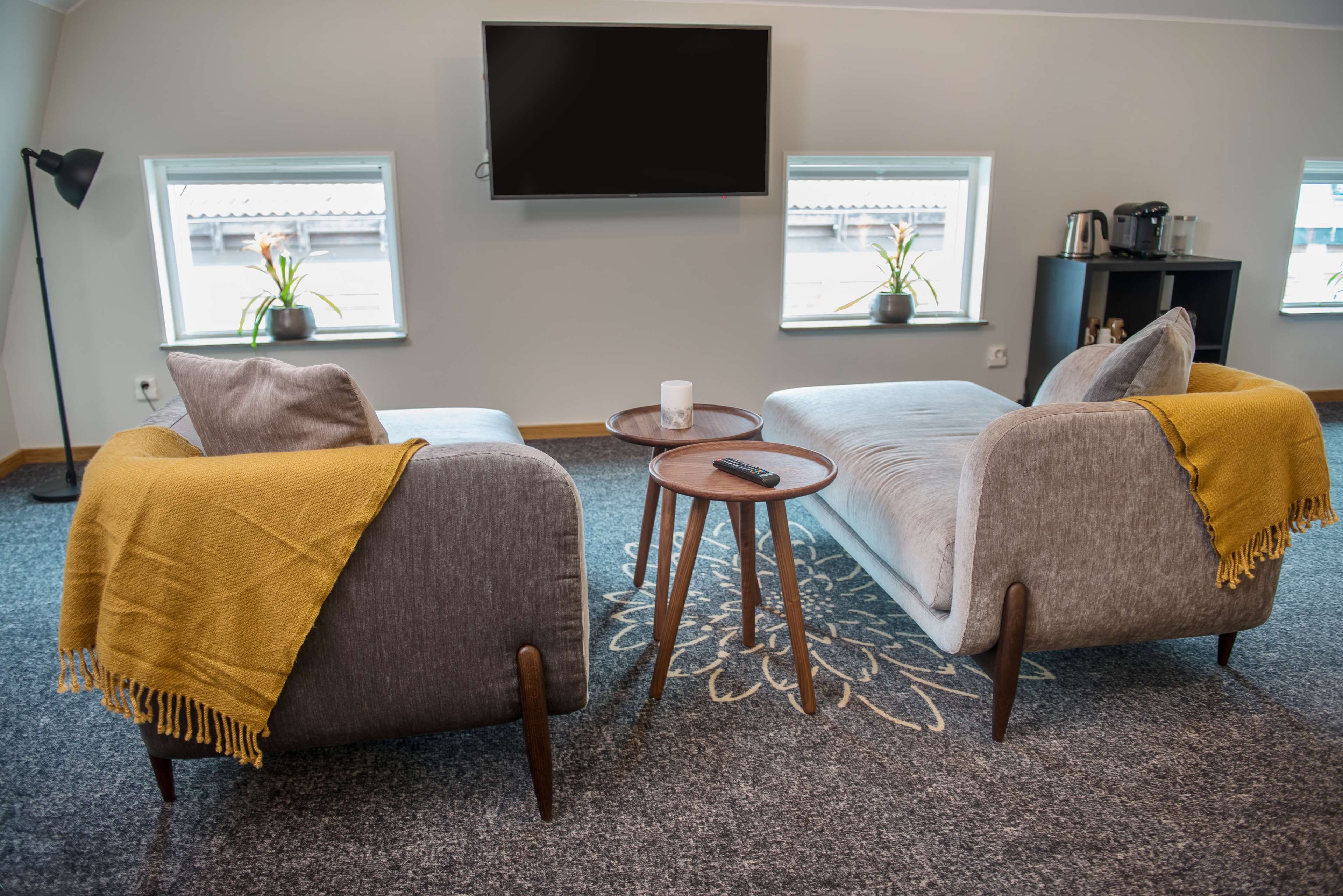 A modern living room with two sofas, a coffee table, and a flat-screen TV.