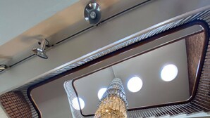 A staircase with a modern design, featuring a metallic railing and a decorative chandelier. - Hotell Alfred Nobel (Karlskoga)