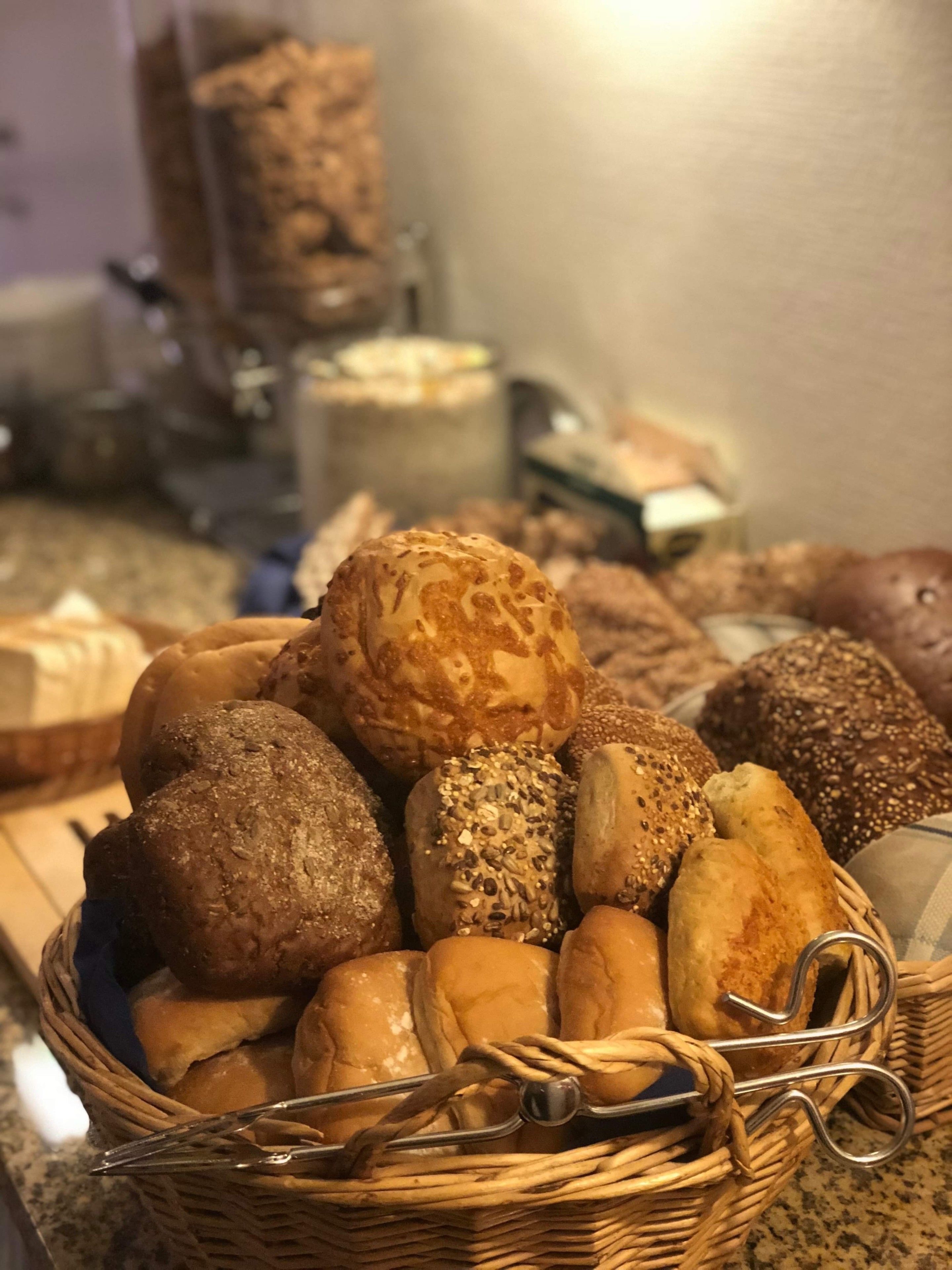 Una cesta con panes y pastelería variados.