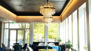 Un intérieur moderne agrémenté d’un grand lustre, de sièges confortables et de larges fenêtres laissant entrer la lumière naturelle.