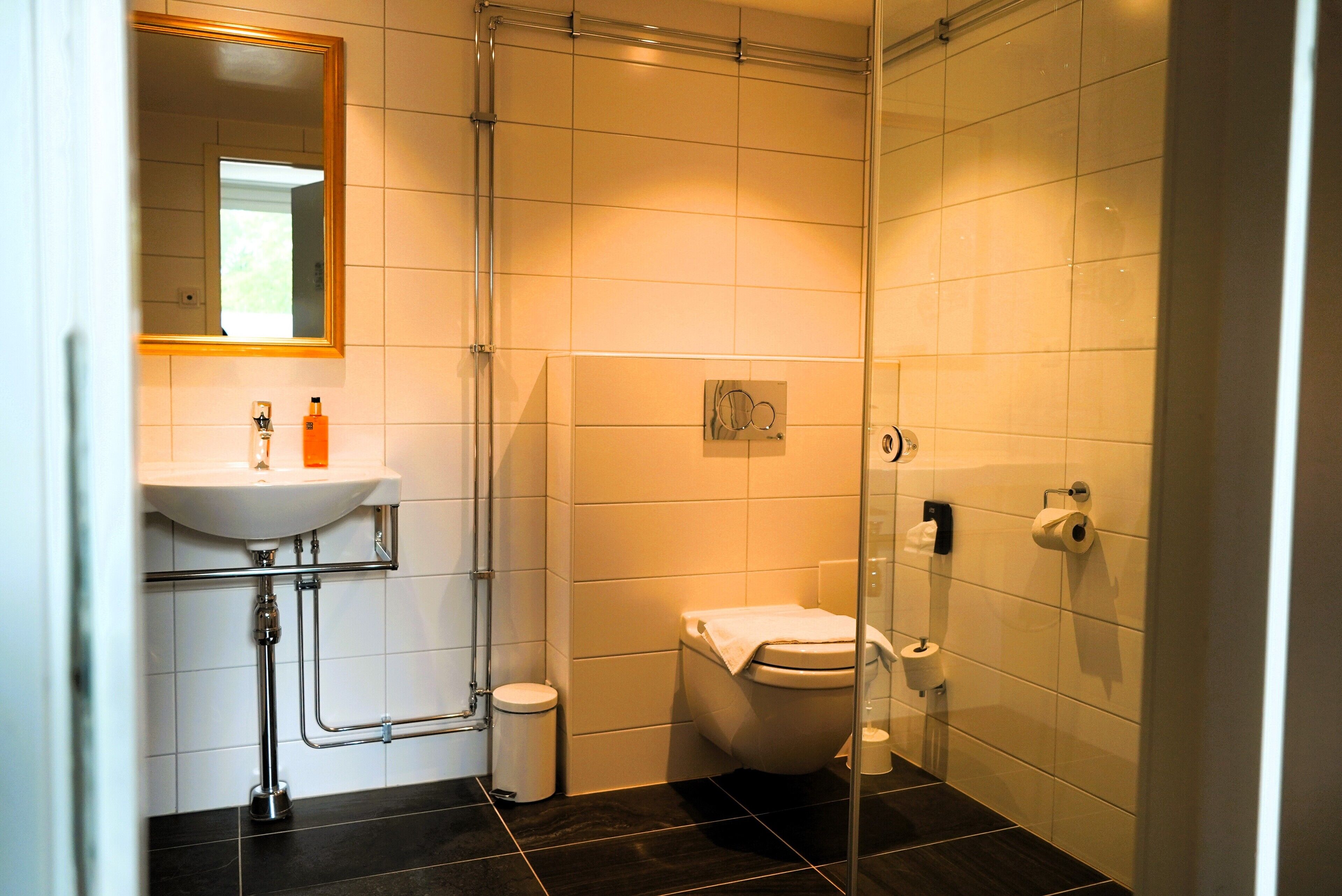 A bathroom with a white sink, a toilet, and a glass shower enclosure.