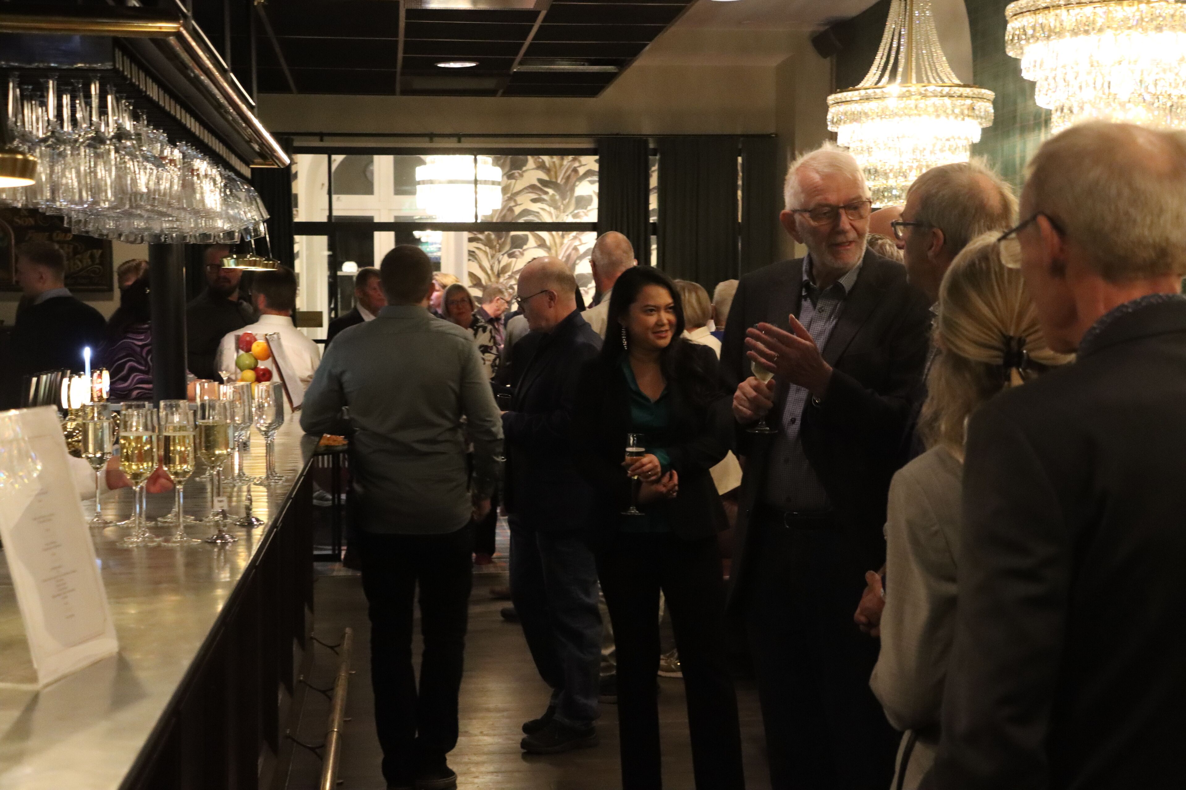 A bar area with a long counter, glasses, and a menu.