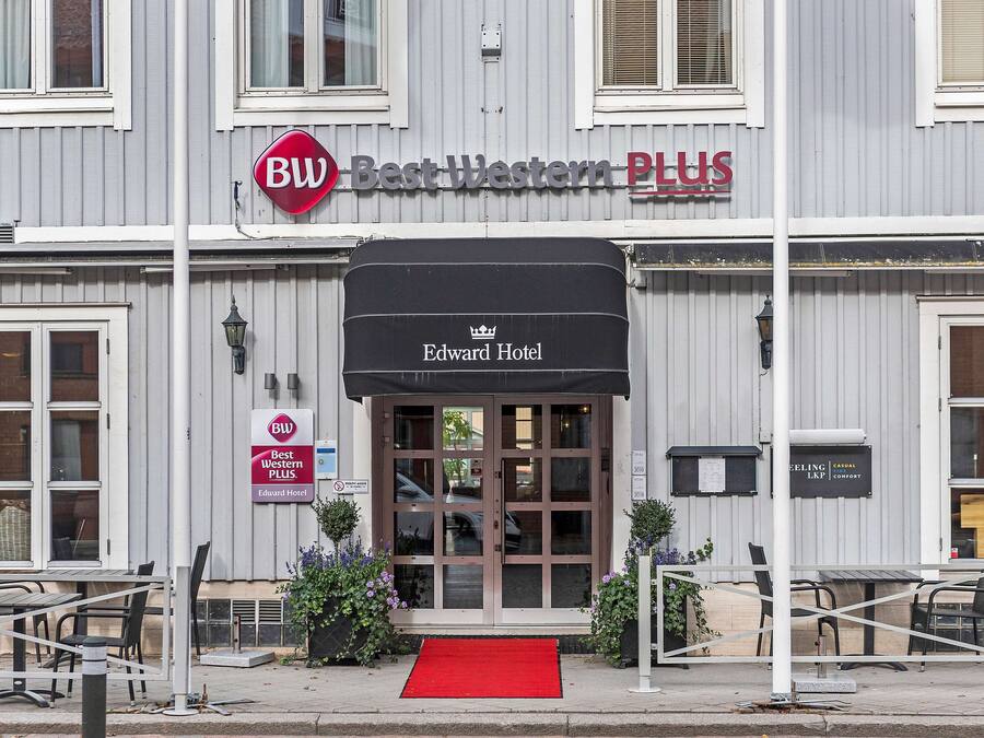 The exterior of the Edward Hotel with a red carpet entrance, a Best Western Plus sign, and a wheelchair accessibility sign.