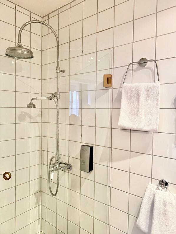 A bathroom with a shower, a towel rack, and a control panel. - Hotel Concordia (Lund)