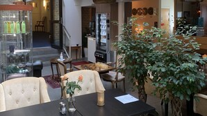 A spacious lobby with a chandelier, seating area, and a vending machine. - Hotel Concordia (Lund)