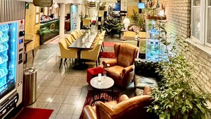 A spacious indoor area with a high ceiling, a central dining table surrounded by chairs, and a Christmas tree. - Hotel Concordia (Lund)