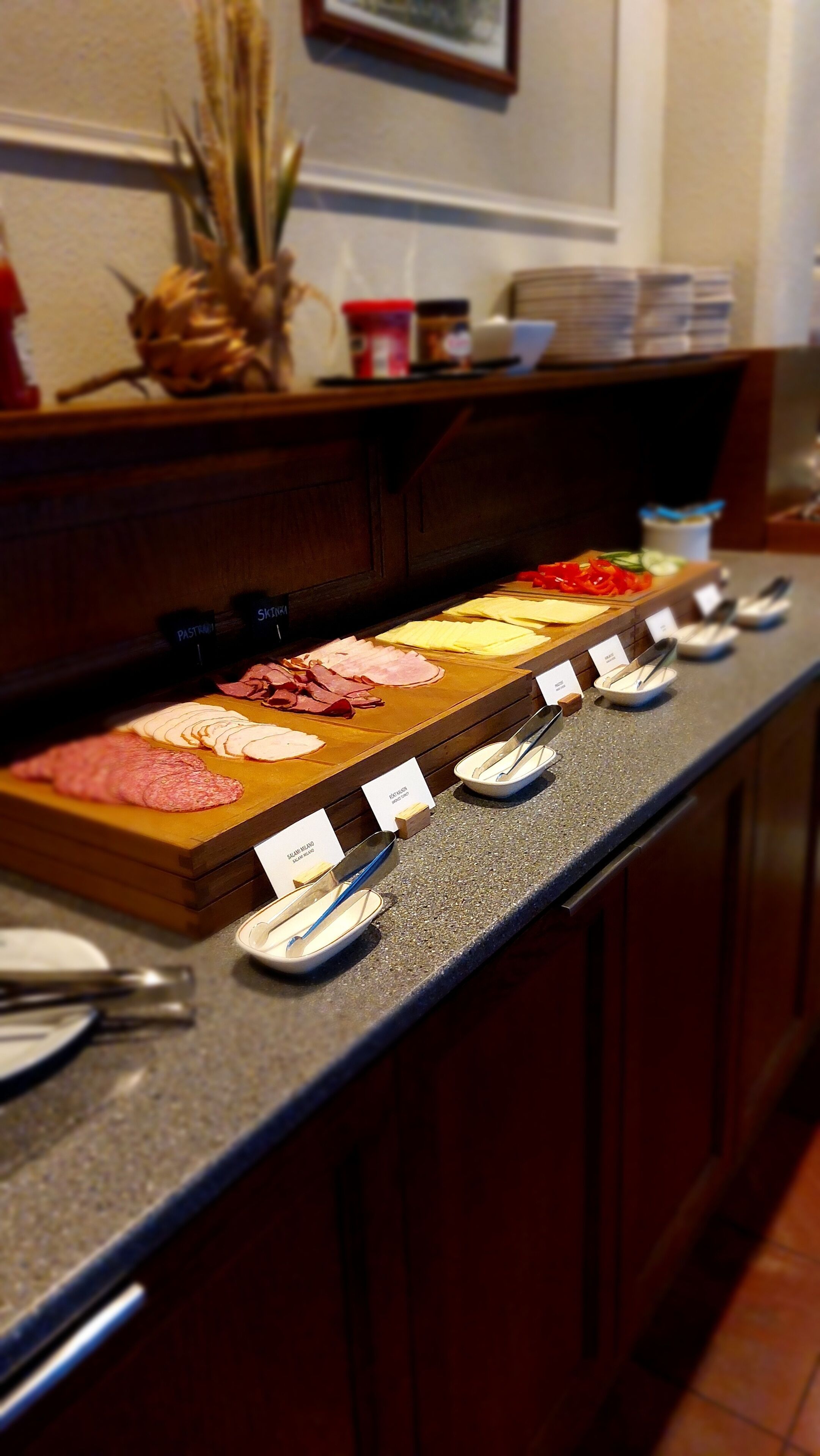 A buffet counter with various food items and serving utensils.