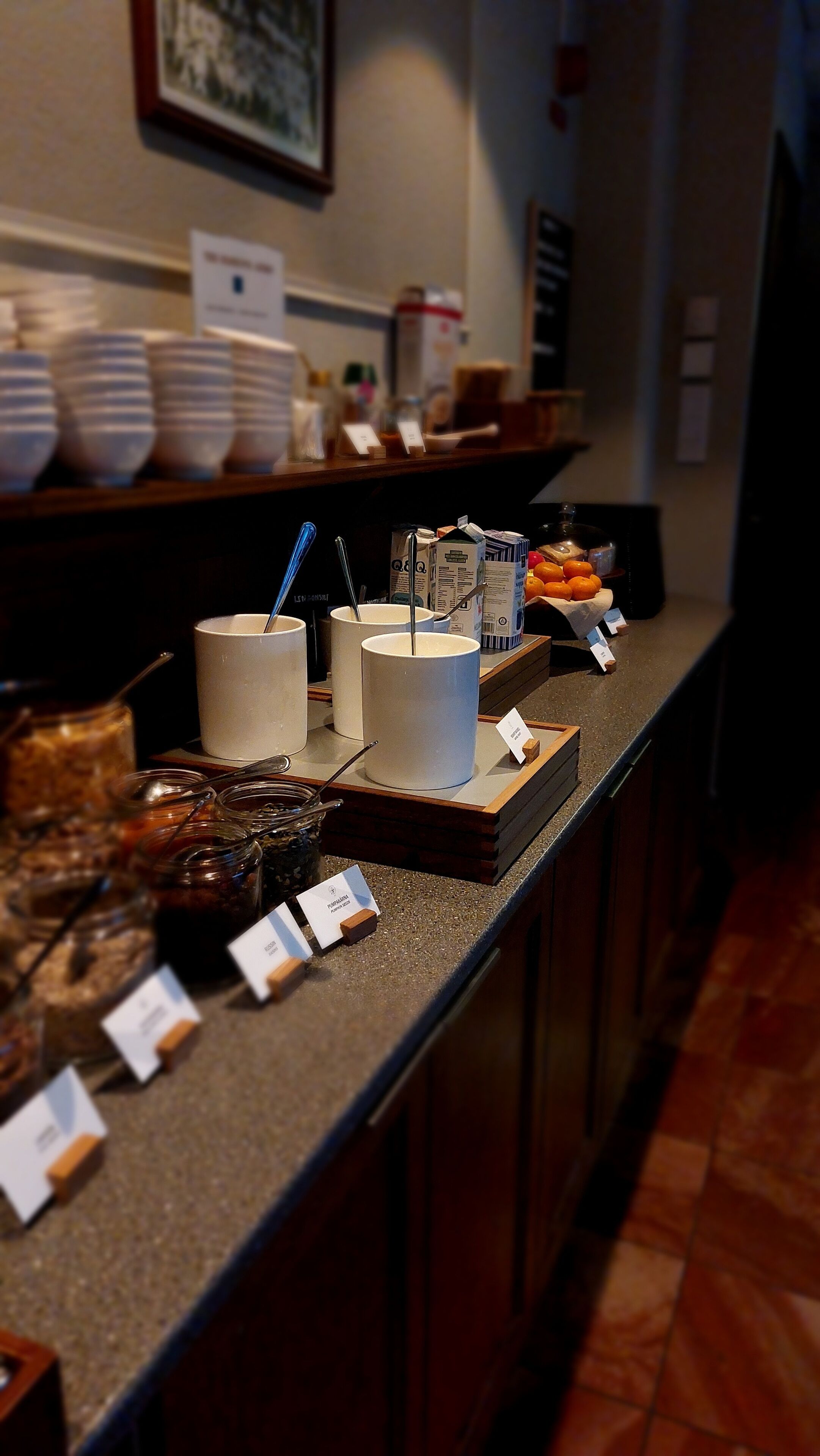A buffet counter with various food items and containers, including bowls, cups, and jars.