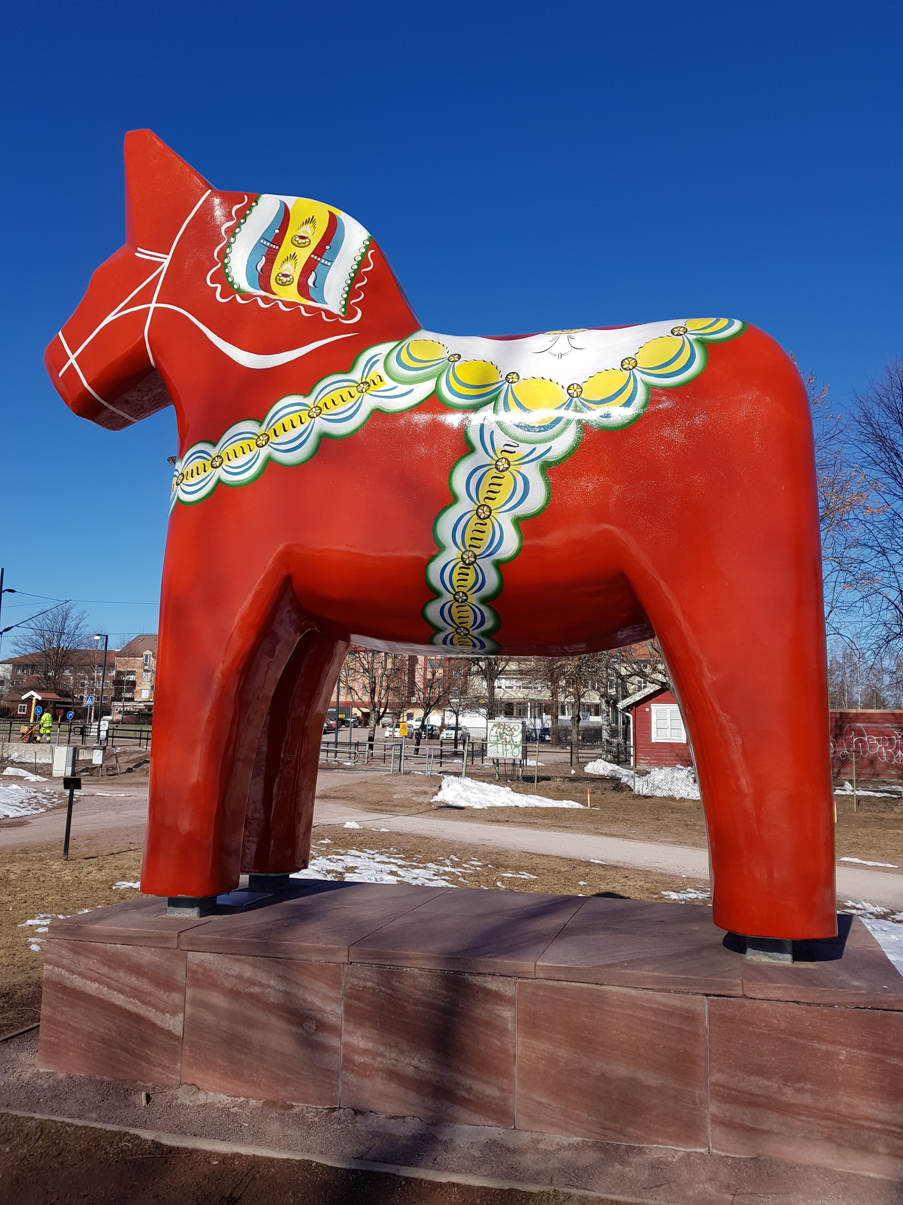 A red horse statue with decorative patterns.