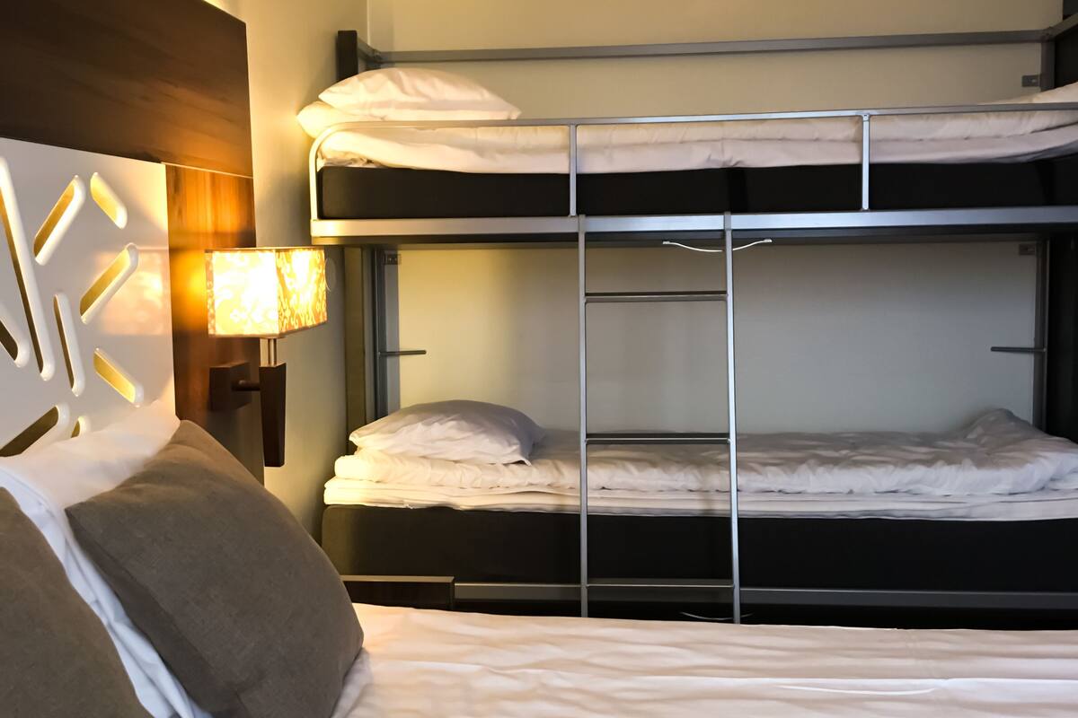 A bunk bed room with a bedside lamp and a nightstand.
