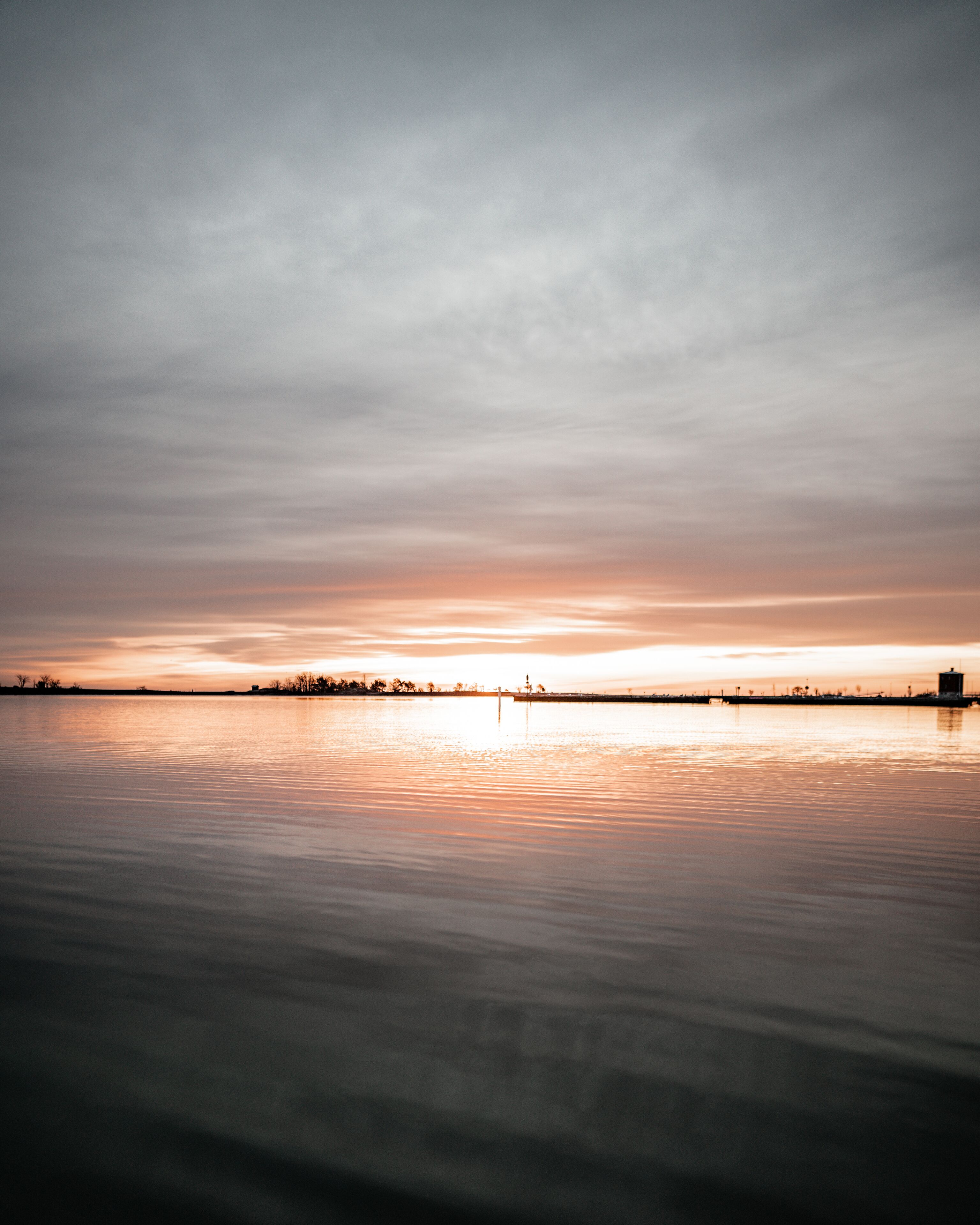 A calm body of water reflecting a sunset.