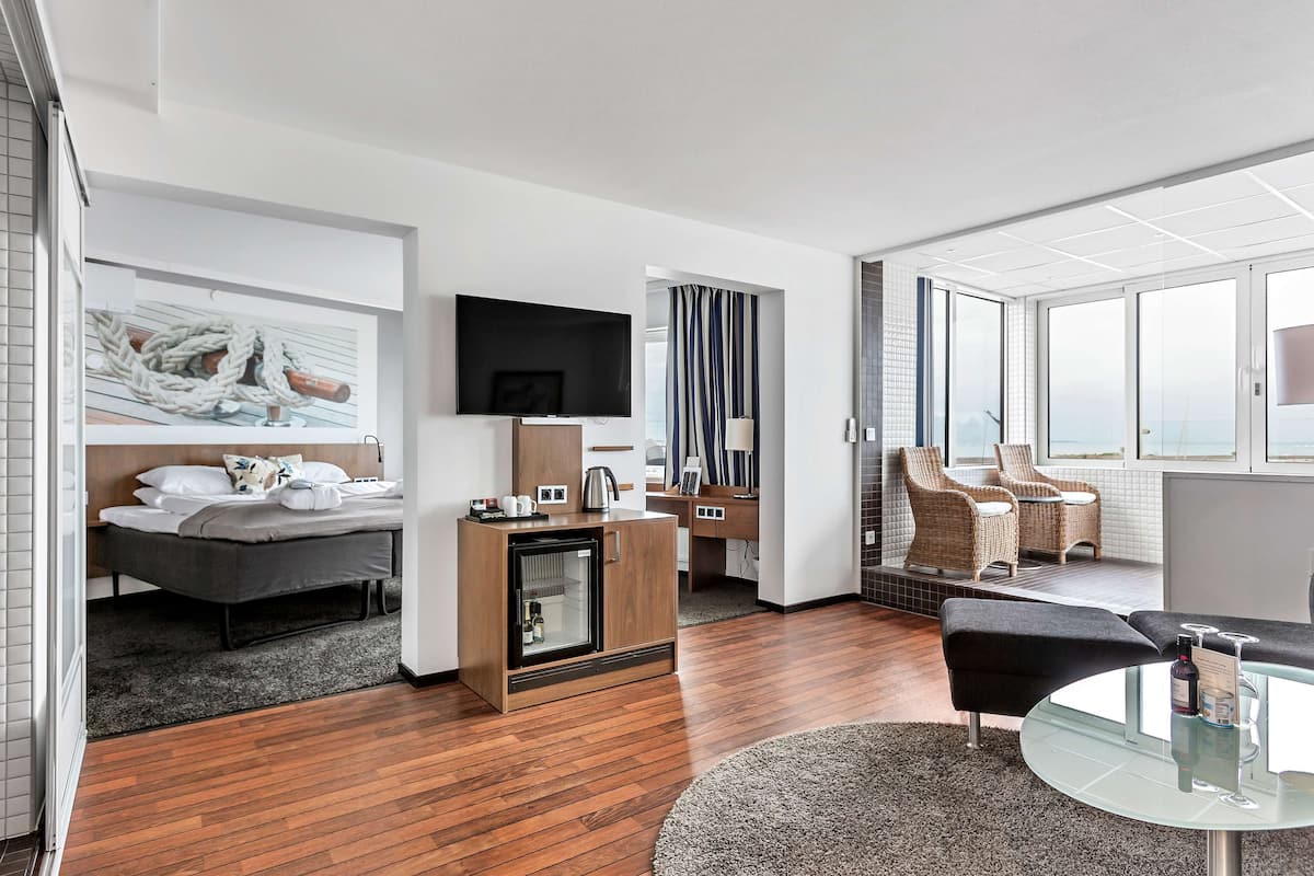 Suite, 1 queensize bed, bubbelbad, uitzicht op zee | Woonkamer | Een 32-inch lcd-televisie met kabelzenders en een televisie