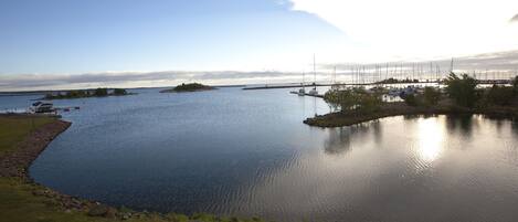 A calm lake with boats, a dock, and a small island.