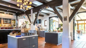 A restaurant with a bar area, wooden beams, and a tiled floor. - Home Hotel Carlscrona (Karlskrona)