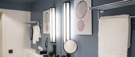 A bathroom with a white sink, a mirror, and a towel rack.
