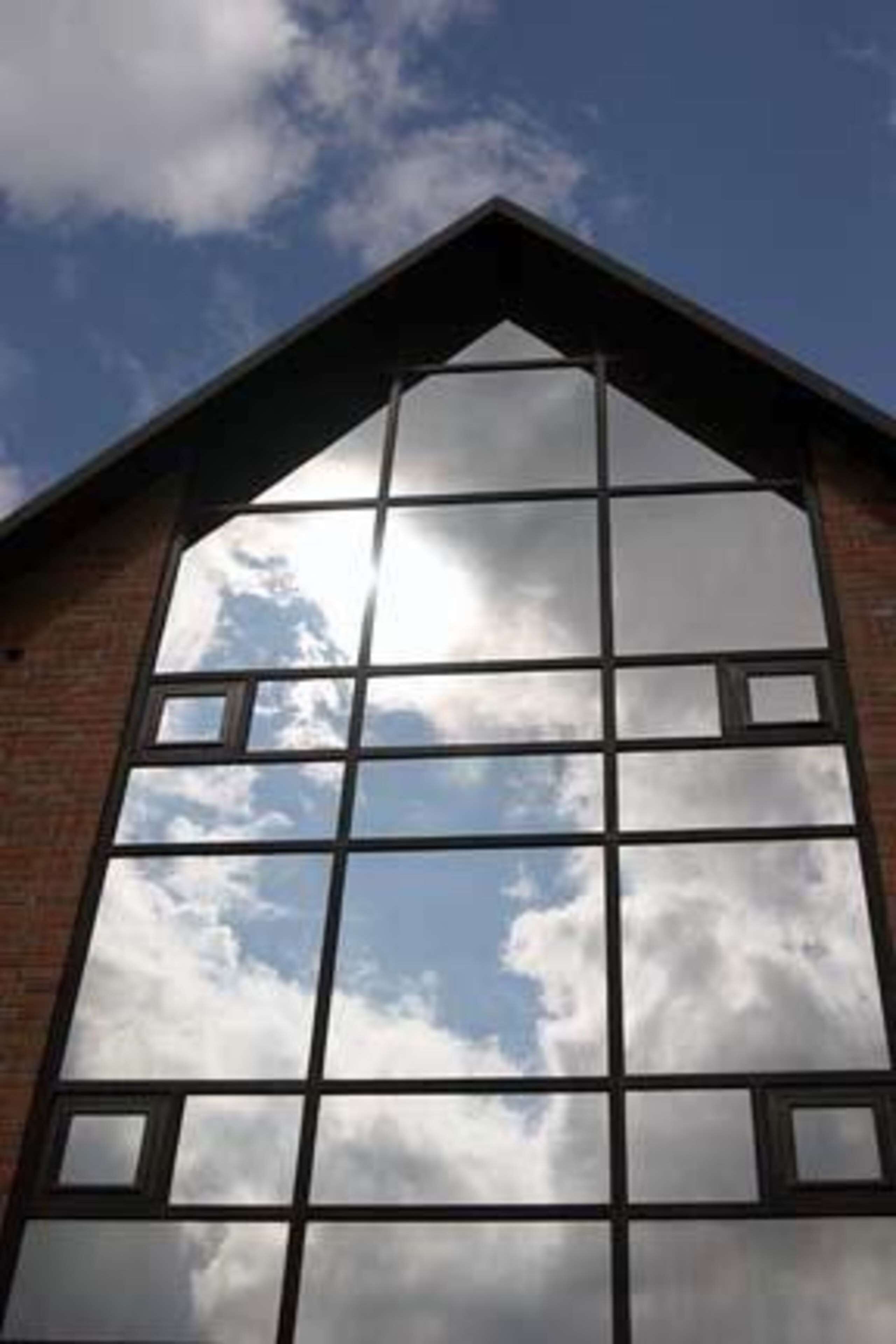 A building with a large, grid-like window structure reflecting the sky.