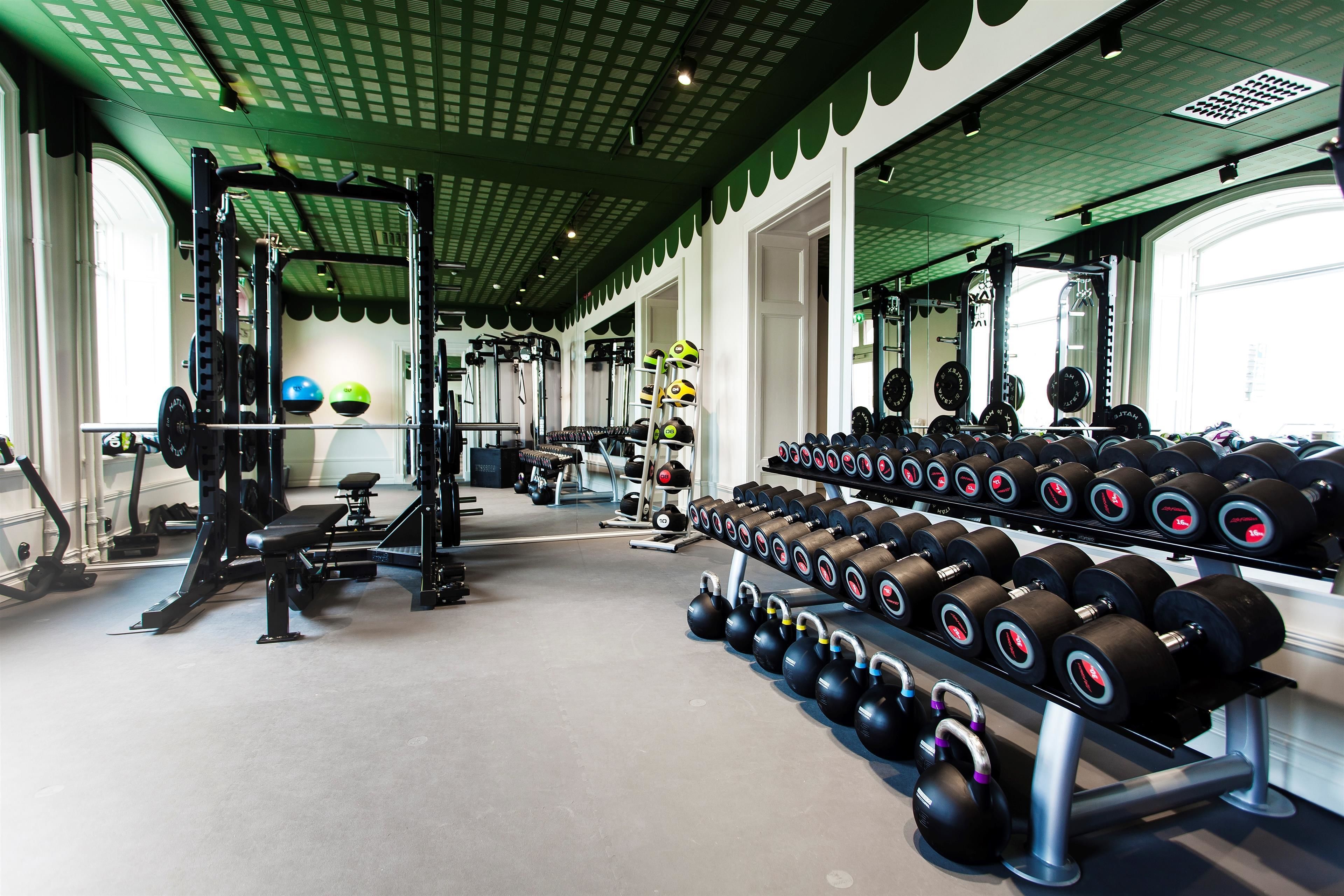 Een sportschool met gewichthefapparatuur, loopbanden en fitnessballen.