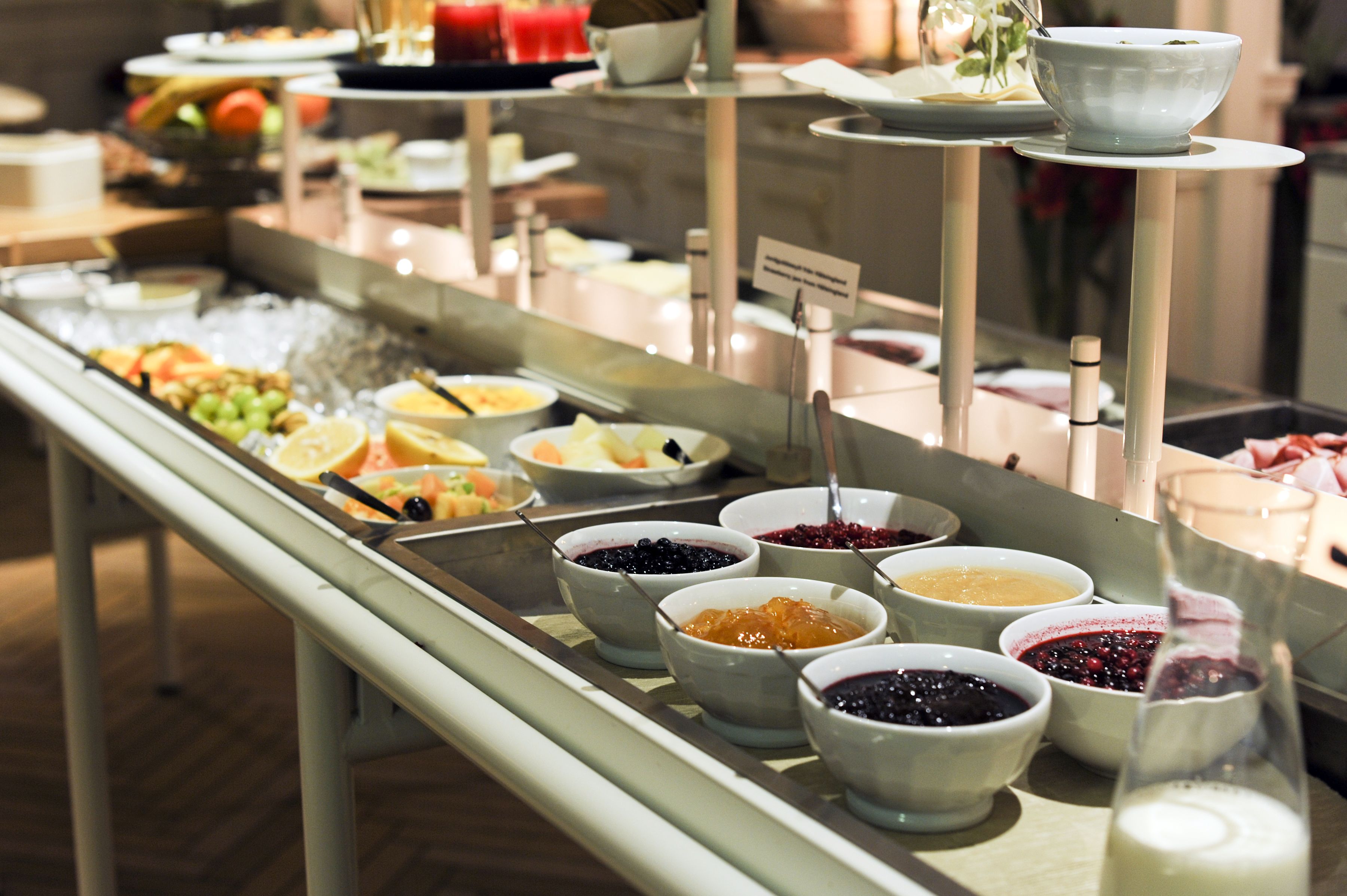 A buffet with various food options including fruits, vegetables, and different types of spreads.
