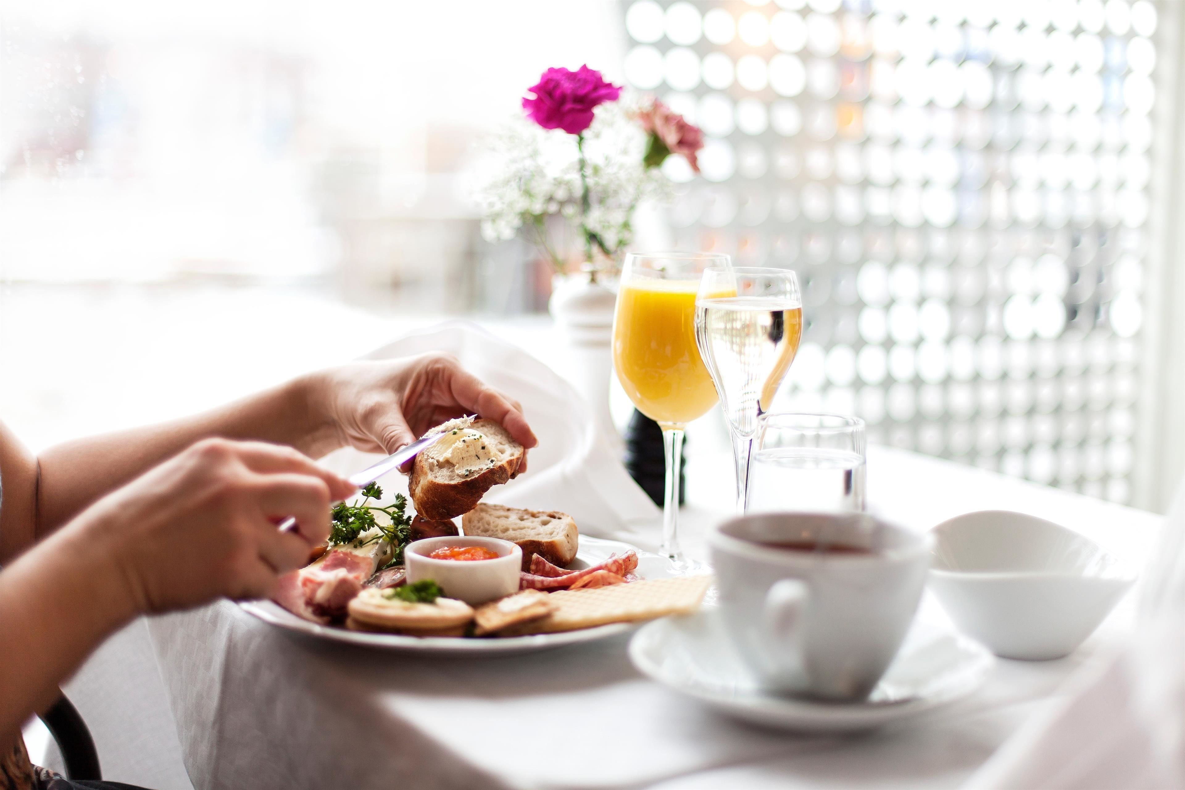 A breakfast setting with a plate of food, a glass of orange juice, and a cup of coffee.