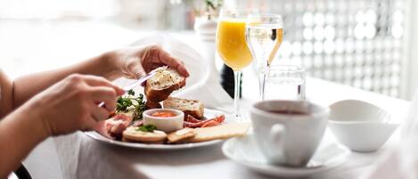 Una mesa con un plato de comida, un vaso de jugo de naranja y una taza de café.