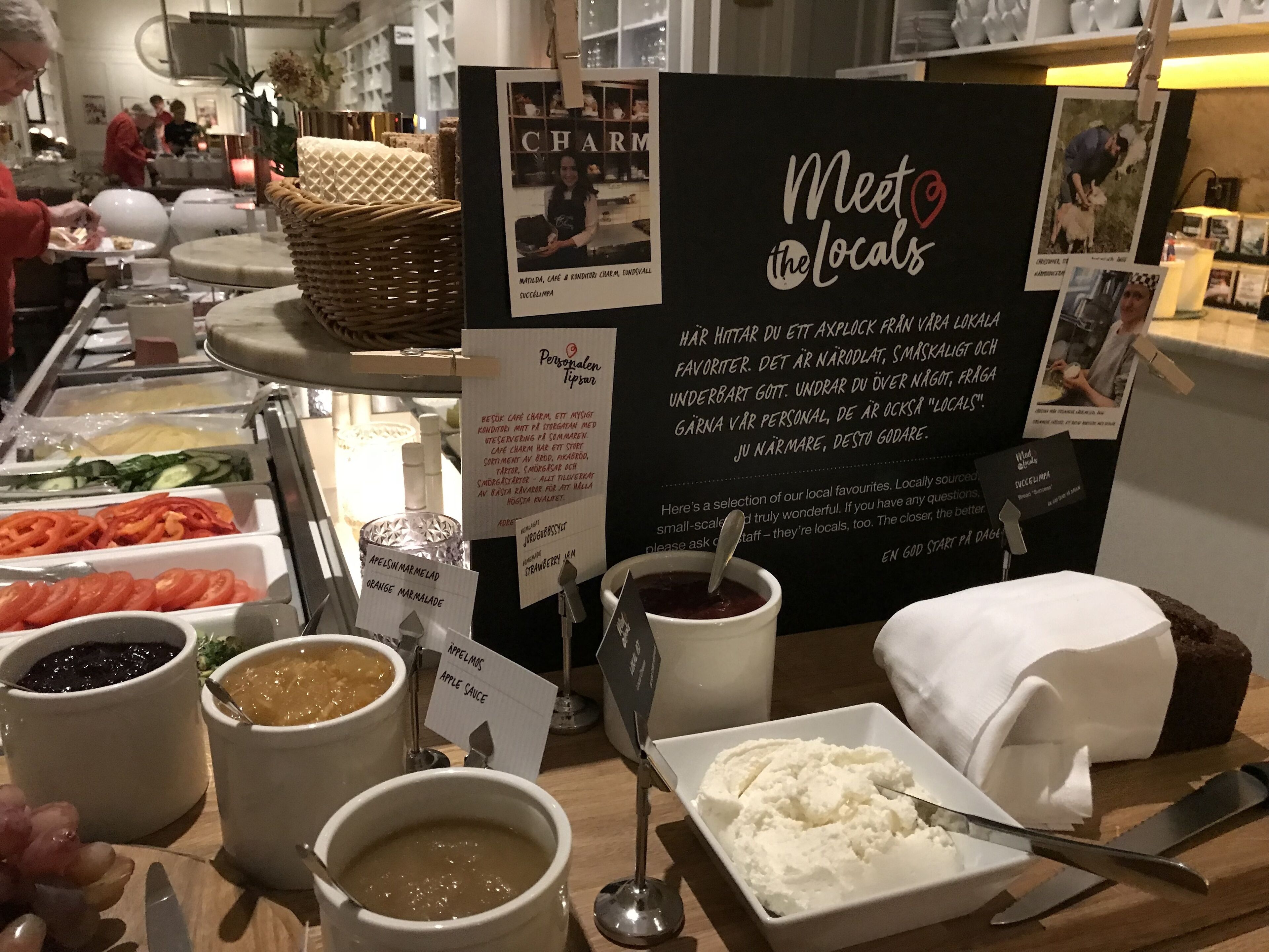 A buffet area with various food items and a sign that reads "Meet the Locals".