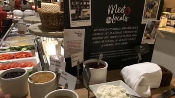 A buffet area with various food items and a sign that reads "Meet the Locals".